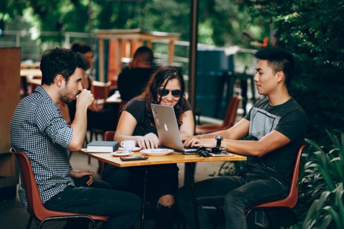 3 people working at a outdoor cafe table