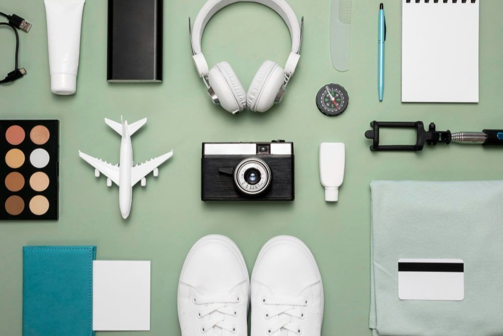 Assortment of travel essentials, tech gadgets, and personal care products arranged on a surface