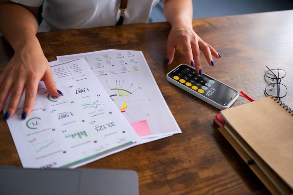 High angle view of a woman working diligently to calculate numbers at the desk