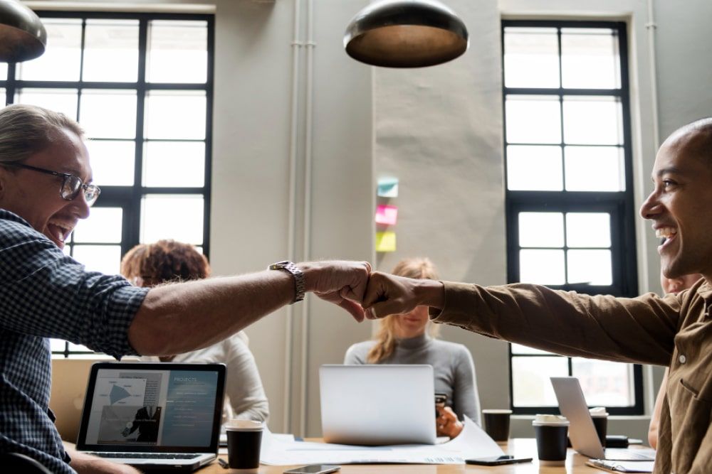 Two businessmen fist bumping - Brick Studio