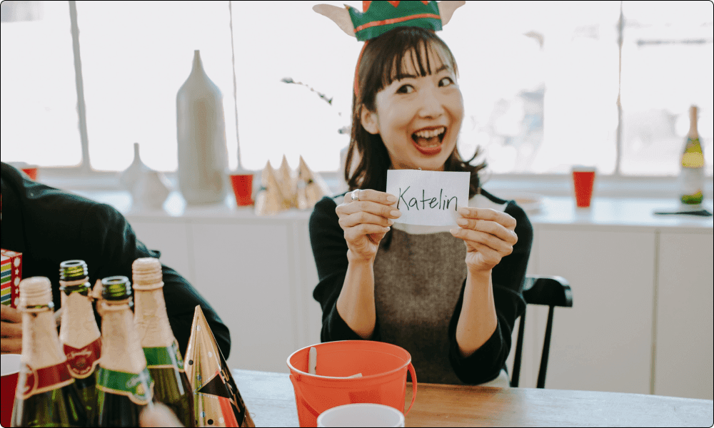 asian female coworker picking names for the secret santa game