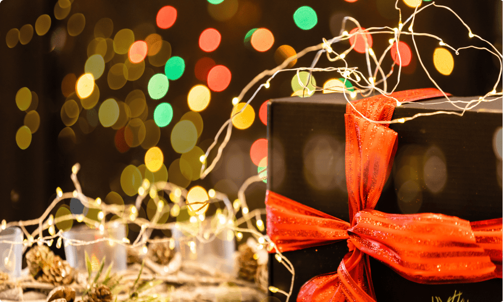 beautifully wrapped gift box with christmas decoration in the background