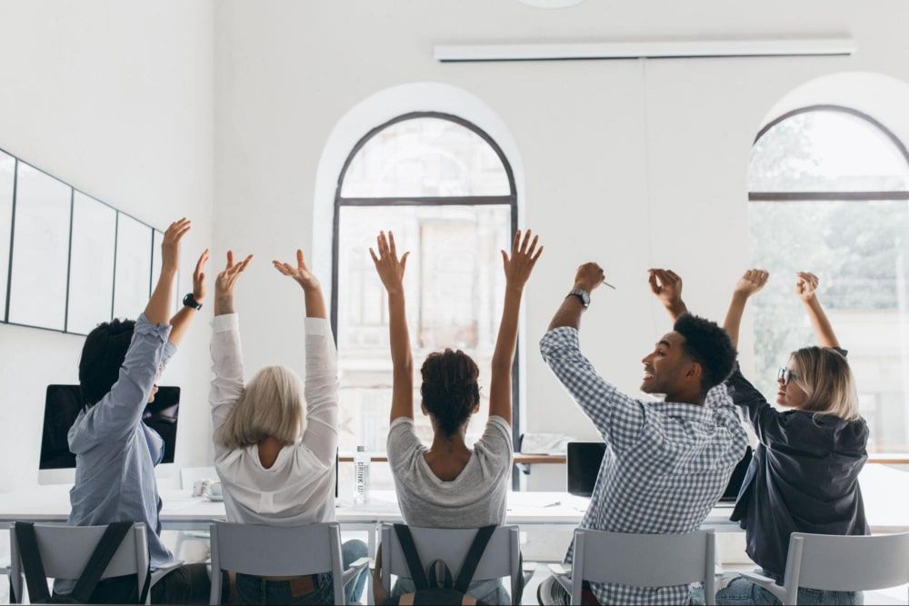 businesswoman with blonde hair waving hands in a formal shirt - culture of recognition in the workplace