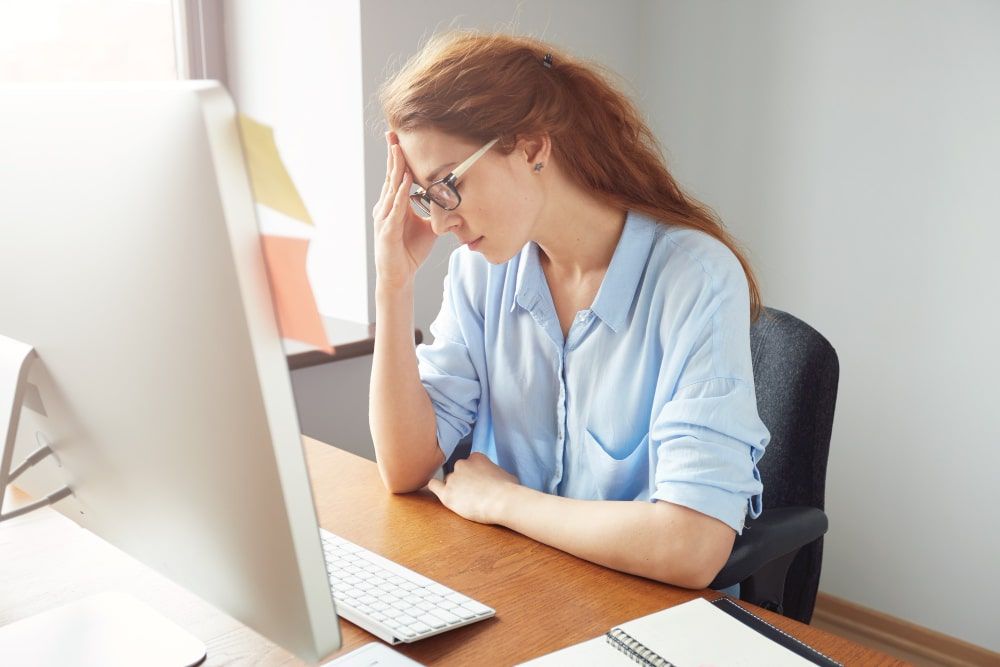 concerned female worker looking computer screen while working office