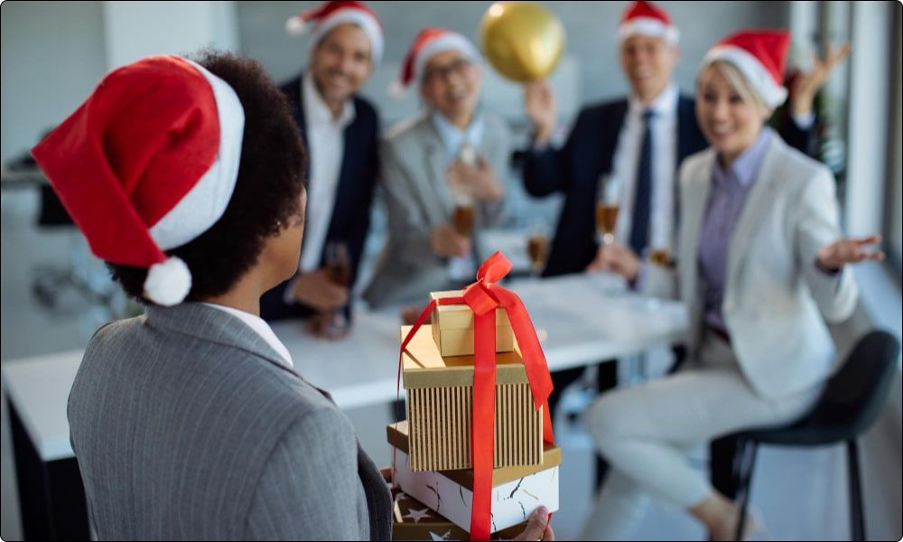 coworkers celebrating christmas by giving each other gifts