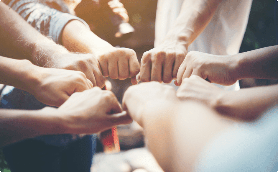 happy team members doing a fist bump - modern employee recognition programs