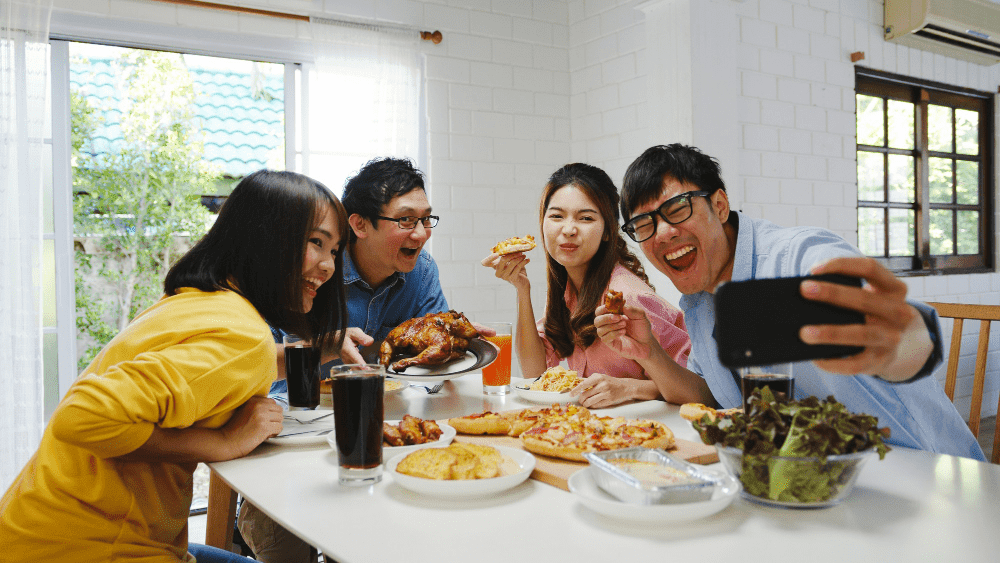 happy young group of friends having lunch together - employee recognition examples