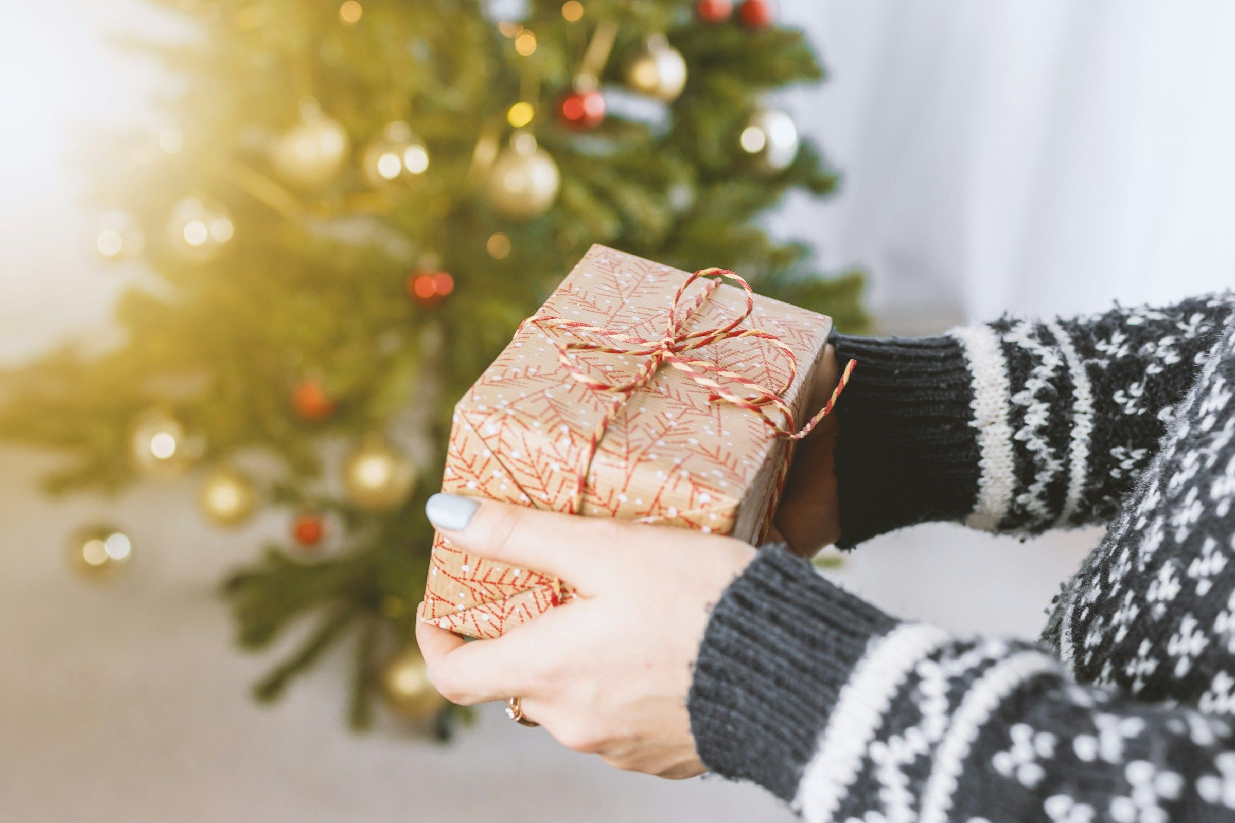 woman holding a gift - New Year Gifts For Employees