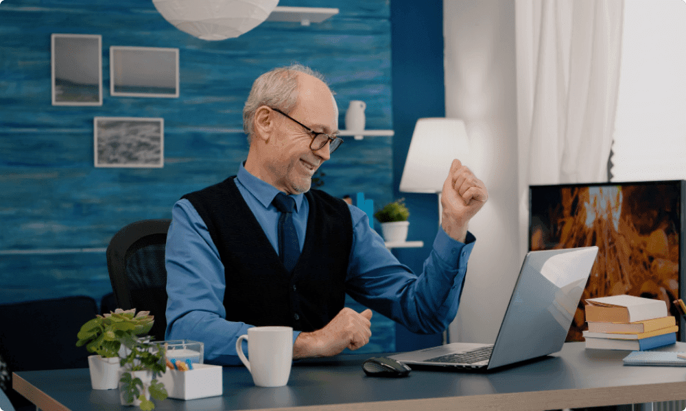 old person sitting in front of a laptop ready to retire after receiving custom retirement gifts