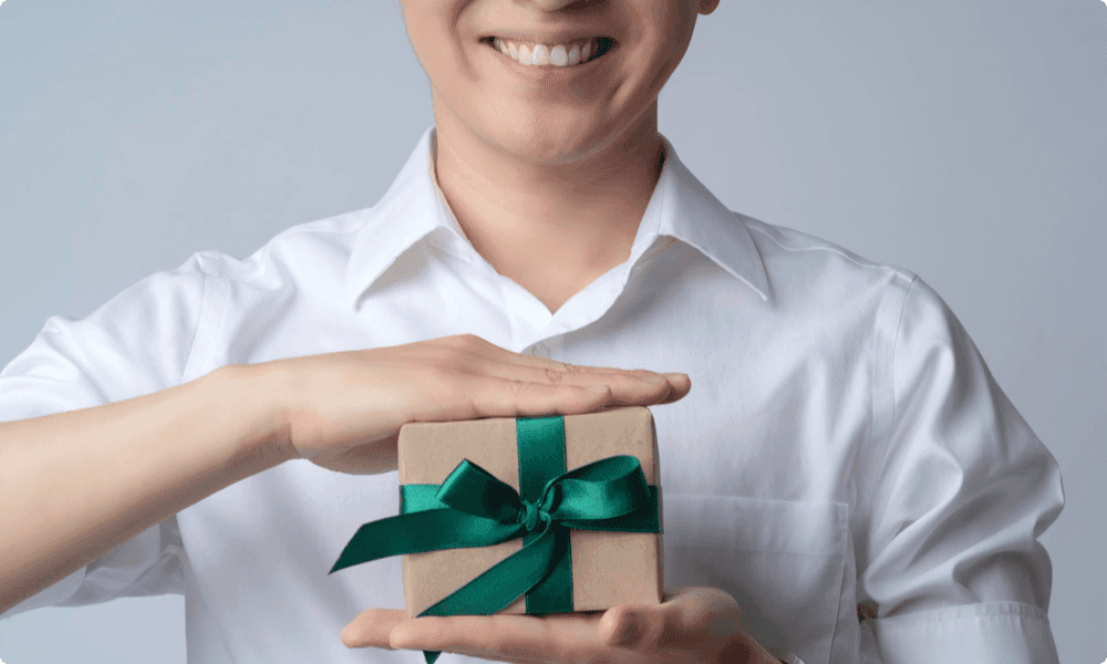 person with smile holding one of his personalized photographer client gifts