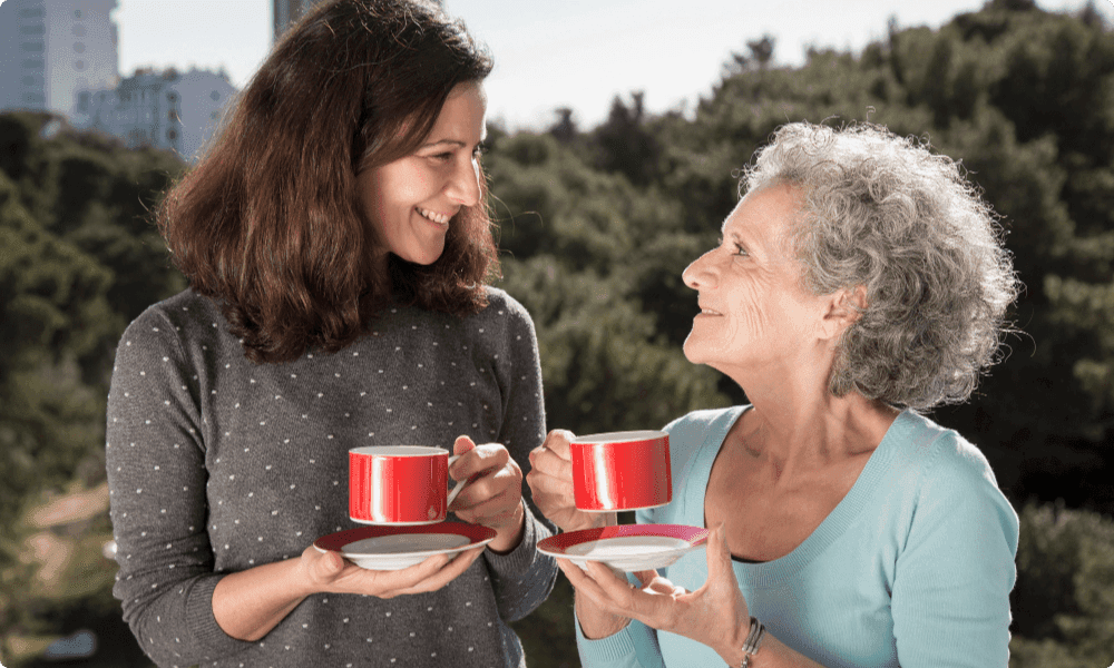 portrait happy senior mother drinking tea with her daugther