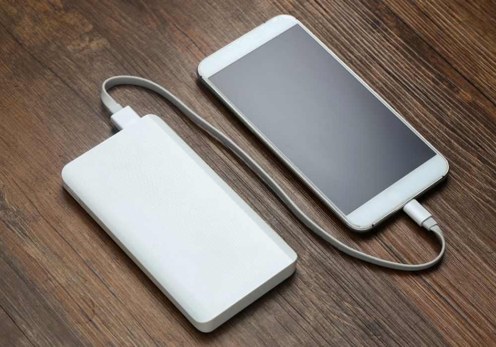 powerbank and cellphone on a wooden-table