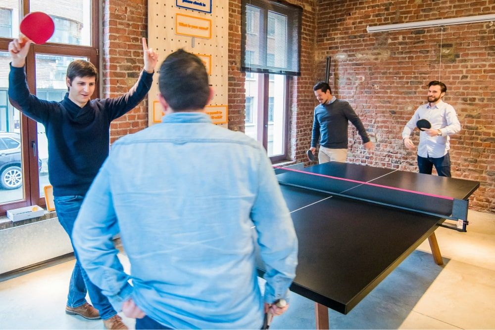 teammates playing table tennis - New Year Team Building Activities