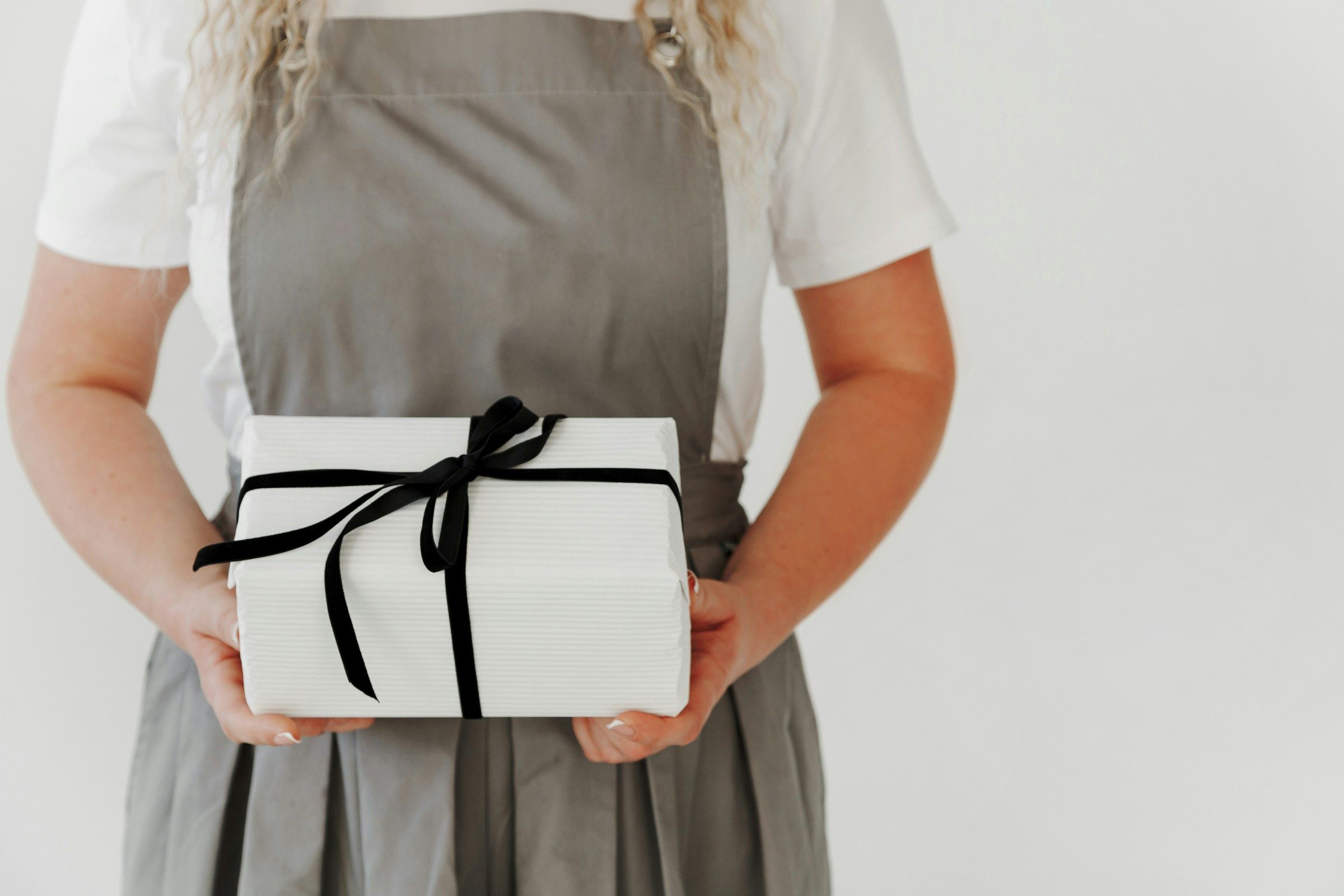 woman holding a gift box - Holiday Staff Appreciation Ideas