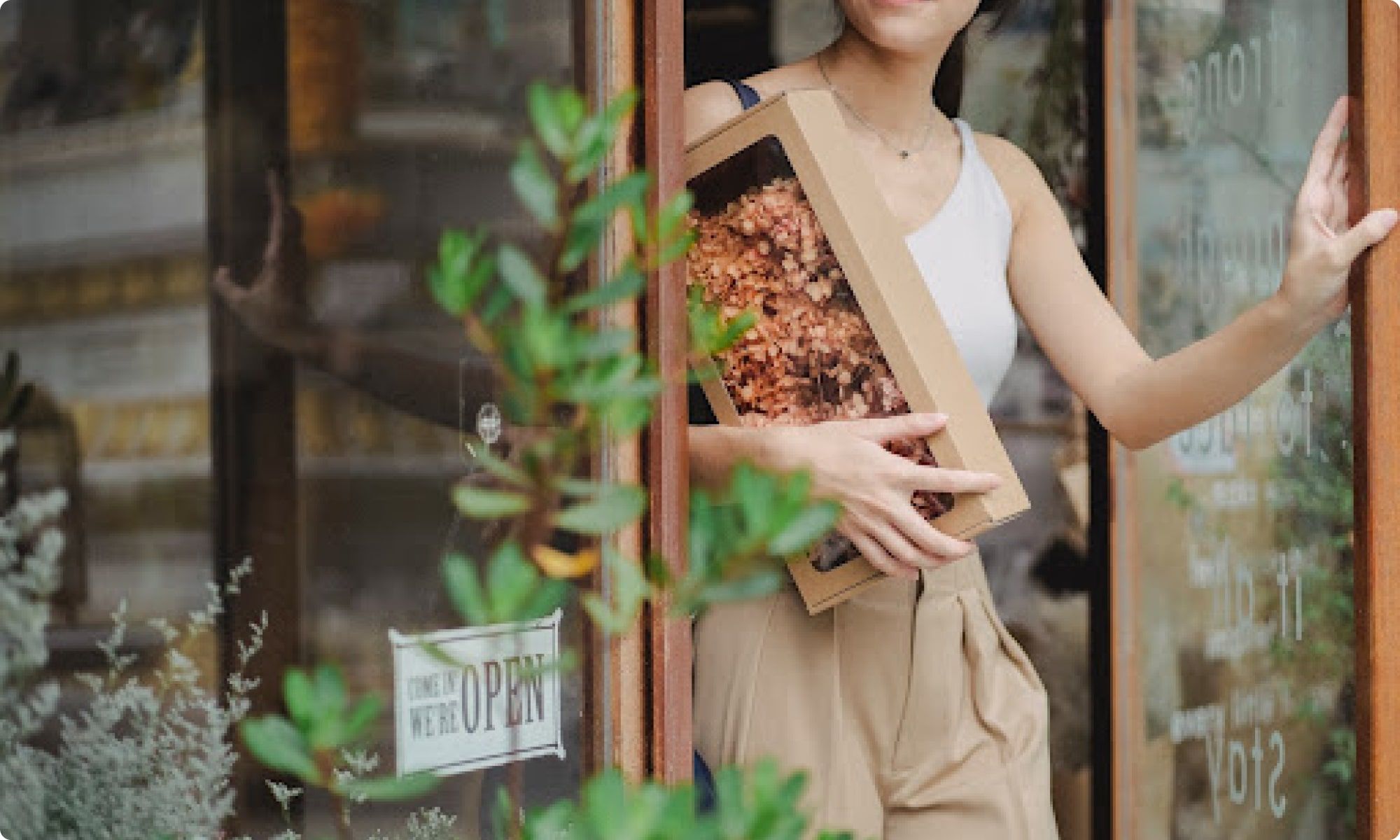 woman carrying a gift box leaving a store