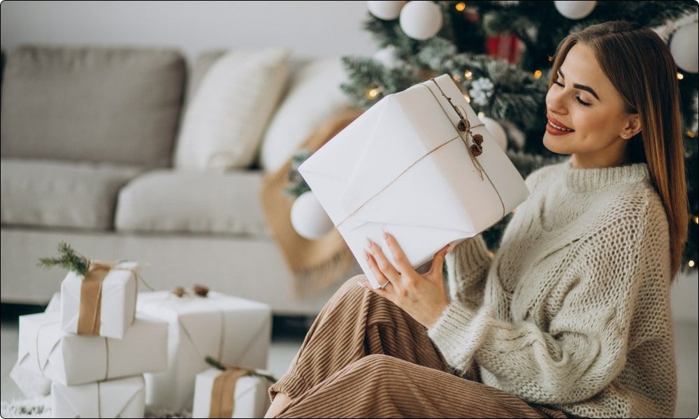 woman looking to open a big gift from office - employee recognition gifts