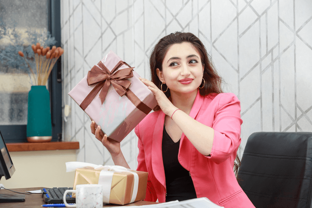 young businesswoman holding present box - best practices for employee recognition