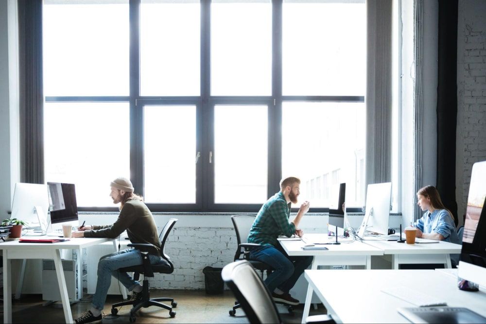 young colleagues working diligently in the office, using computers after successful employee recognition program